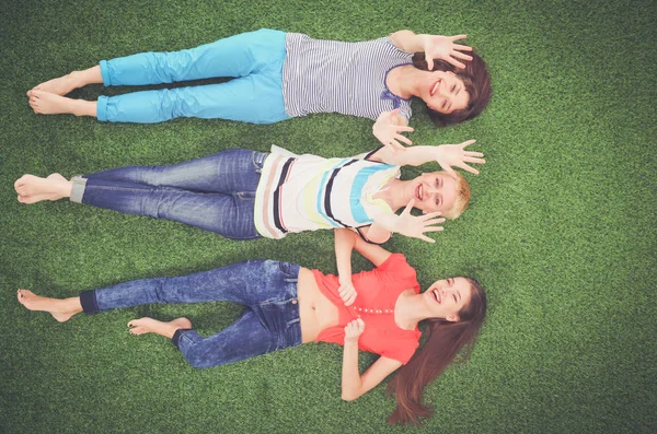 Des jeunes femmes allongées sur de l'herbe verte. Jeunes femmes — Photo
