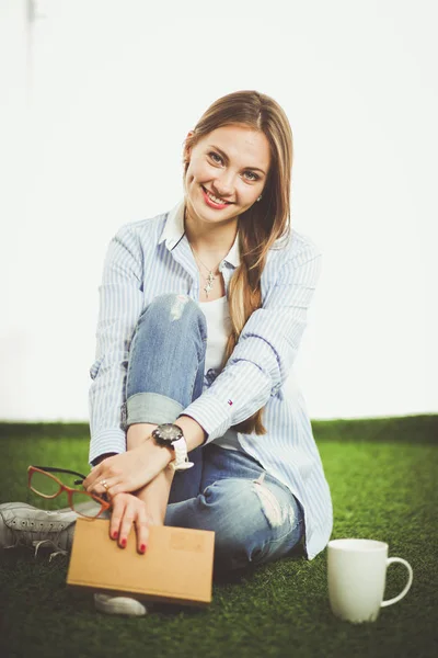 本草の上に座っている若い女性。若い女性 — ストック写真