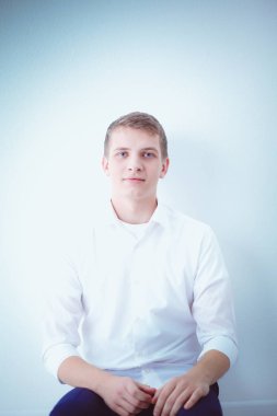 Genç iş adamı ayakta ofisinde çalışıyor. Genç iş adamı