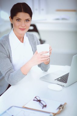 Ofiste Kupası ile masaya oturan genç iş kadını. Genç iş kadını