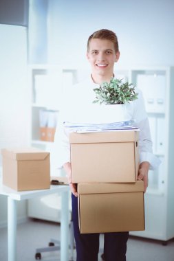 Gri arka plan üzerinde oturan gülümseyen genç adam portresi. Genç adam portresi