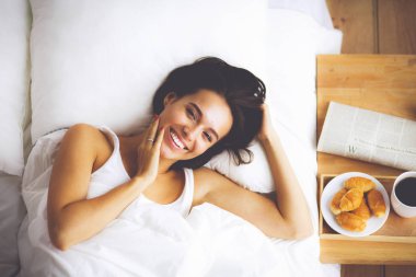 Genç ve güzel bir kadın yatakta yatıyor..