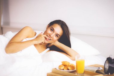 Genç ve güzel bir kadın yatakta yatıyor..