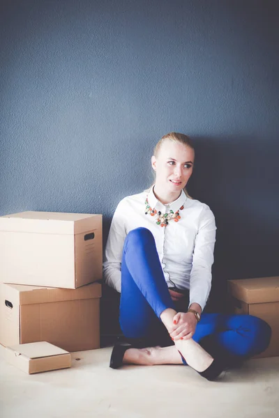 Woman sitting on the floor near a boxes with laptop . Businesswoman — Stock Photo, Image
