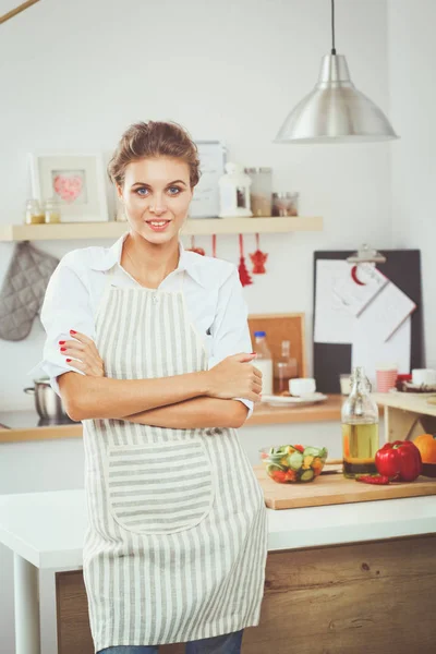 Sorrindo jovem mulher preparando salada na cozinha . — Fotografia de Stock