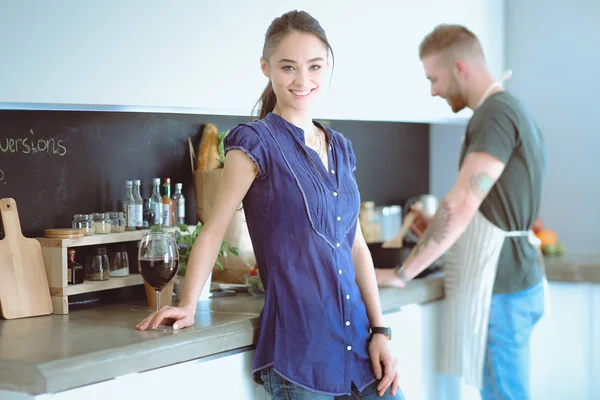 Pareja bebiendo vino mientras cocina en la cocina — Foto de Stock