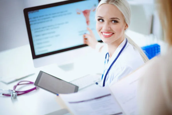 Dokter en patiënt bespreken iets terwijl ze aan tafel zitten. Geneeskunde en gezondheidszorg. Dokter en patiënt — Stockfoto