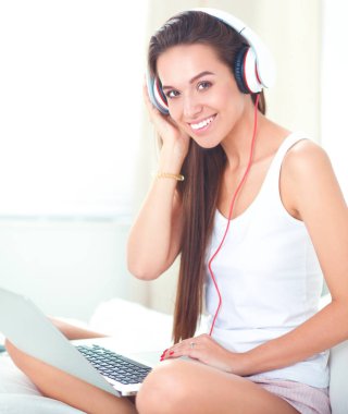 Genç güzel kadın yatakta müzik