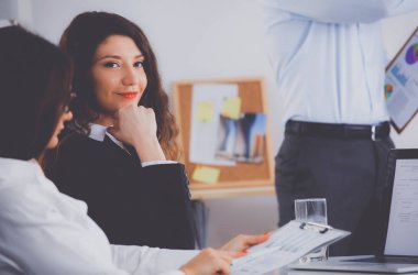 İş adamları iş toplantısında, ofiste oturup tartışıyorlar.