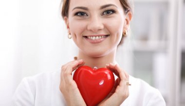 Kalbi tutan steteskoplu bir doktor, beyaz arka planda izole edilmiş.