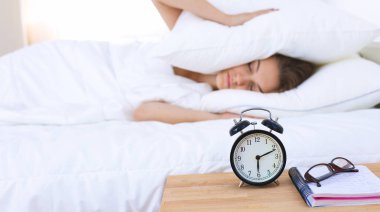 Genç bir kadın sabah alarmını erteliyor.