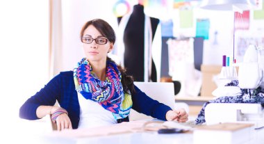 Genç terzi kâğıt üzerinde kıyafet deseni tasarlıyor. .