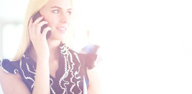 Ofiste cep telefonu kullanan güzel bir iş kadını.