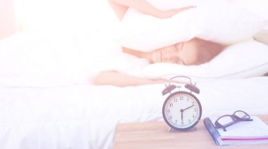 Genç bir kadın sabah alarmını erteliyor.