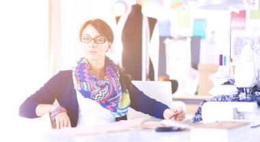 Genç terzi kâğıt üzerinde kıyafet deseni tasarlıyor. .