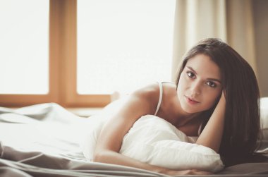 Evdeki yatakta uzanmış güzel esmer