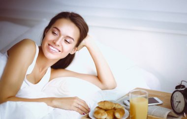 Evde yatakta yatan genç güzel kadın.