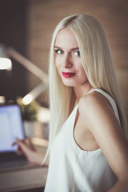 Moda tasarımcıları stüdyoda çalışıyor. Masanın üzerinde oturuyorlar..