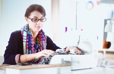 Çalışırken dikiş diken genç bir kadın. .