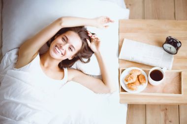 Genç ve güzel bir kadın yatakta yatıyor..