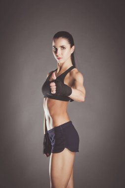 Spor giyim siyah arka plan karşı poz kas genç kadın.