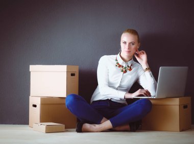 Dizüstü bilgisayar ile bir kutu yakınındaki katta oturan Bayan. İş kadını