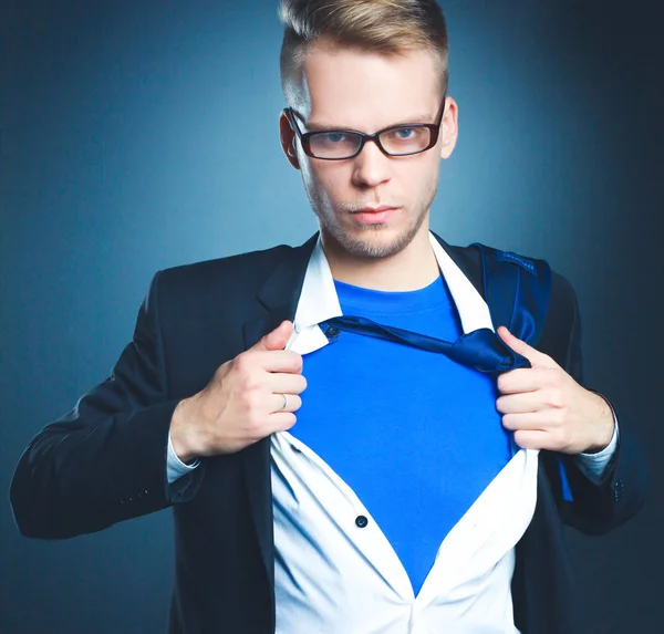 Ung affärsman agerar som en super hjälte och riva sin skjorta, isolerad på grå bakgrund — Stockfoto