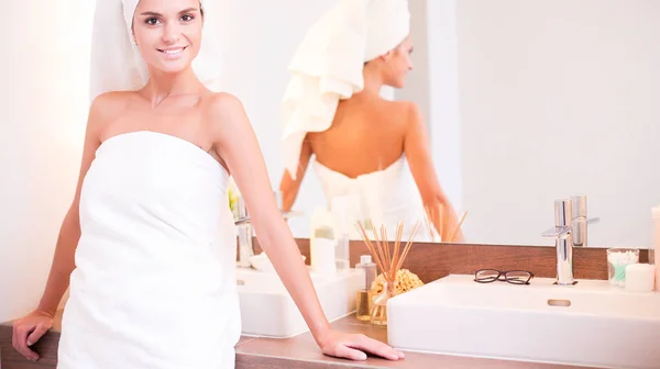 Jovem mulher atraente em pé na frente do espelho do banheiro — Fotografia de Stock