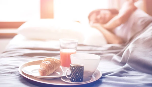 Молода жінка сидить у ліжку з чашкою молока — стокове фото