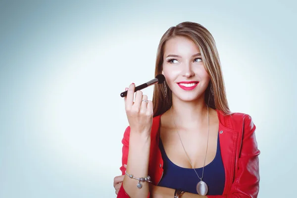 Unga vackra kvinnan håller i hand borste för makeup . — Stockfoto