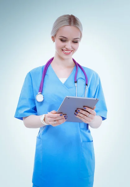 Žena lékař pomocí digitálního tabletu a stojí na bílém pozadí. Ženský doktoři. — Stock fotografie