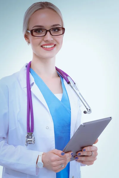 Médica usando um comprimido digital e de pé sobre fundo branco. Mulheres médicas. — Fotografia de Stock