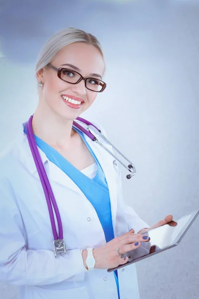 Médica usando um comprimido digital e de pé sobre fundo branco. Mulheres médicas. — Fotografia de Stock