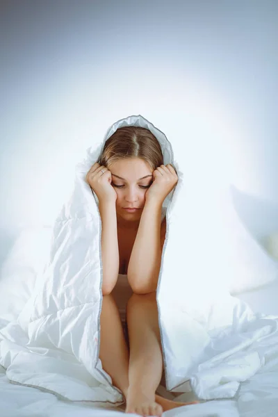 Wanita cantik muda berbaring di tempat tidur di bawah penutup. — Stok Foto