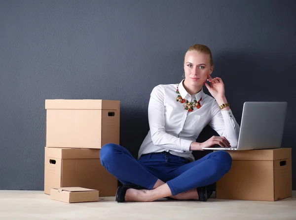 Mujer sentada en el suelo cerca de una caja con portátil. Empresaria —  Fotos de Stock