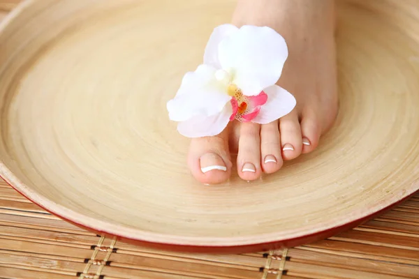 Pflege für schöne Frauenbeine mit Blüte. schöne Frauenbeine — Stockfoto