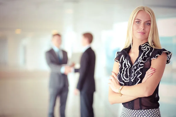 Portret van jonge zakenvrouw in functie met collega 's op de achtergrond . — Stockfoto