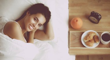 Evde yatakta yatan genç güzel kadın