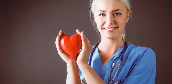 Jonge arts vrouw met de stethoscoop houden hart — Stockfoto