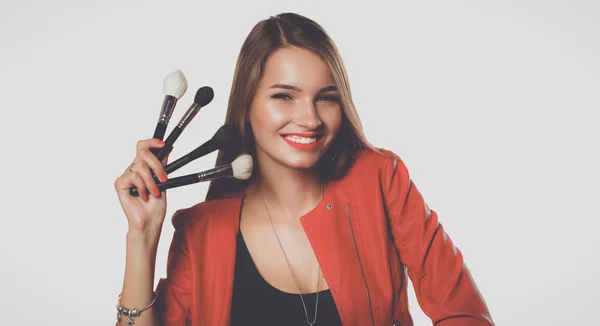 Joven hermosa mujer sostiene en cepillo de mano para el maquillaje — Foto de Stock