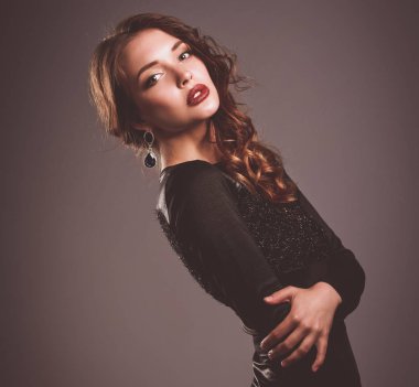 Siyah elbiseli, akşam makyajlı güzel bir kadın.