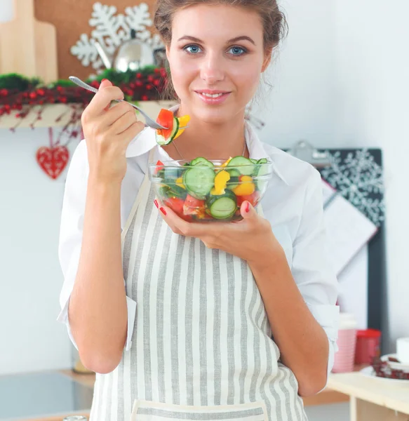 Молода жінка їсть свіжий салат на сучасній кухні — стокове фото