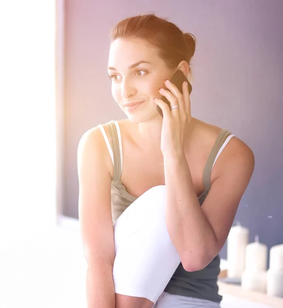 Attraktive kaukasische Mädchen sitzen auf dem Boden mit Telefon — Stockfoto