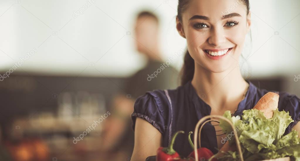 Young couple in the kitchen , woman with a bag of groceries shopping