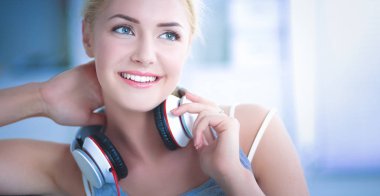 Evdeki genç ve güzel kadın kanepede oturup müzik dinliyor.
