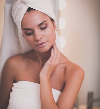 Banyo aynası önünde duran genç çekici kadın