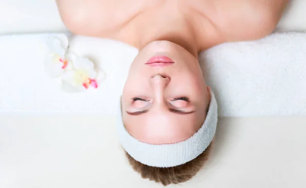 Beautiful young woman getting spa massage, lying on salon — Stock Photo, Image