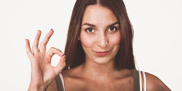 Szczęśliwa młoda kobieta pokazuje ok znak palcami — Zdjęcie stockowe