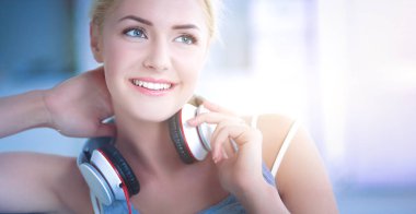 Evdeki genç ve güzel kadın kanepede oturup müzik dinliyor.