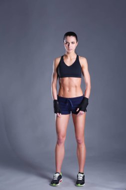 Spor giyim siyah arka plan karşı poz kas genç kadın.